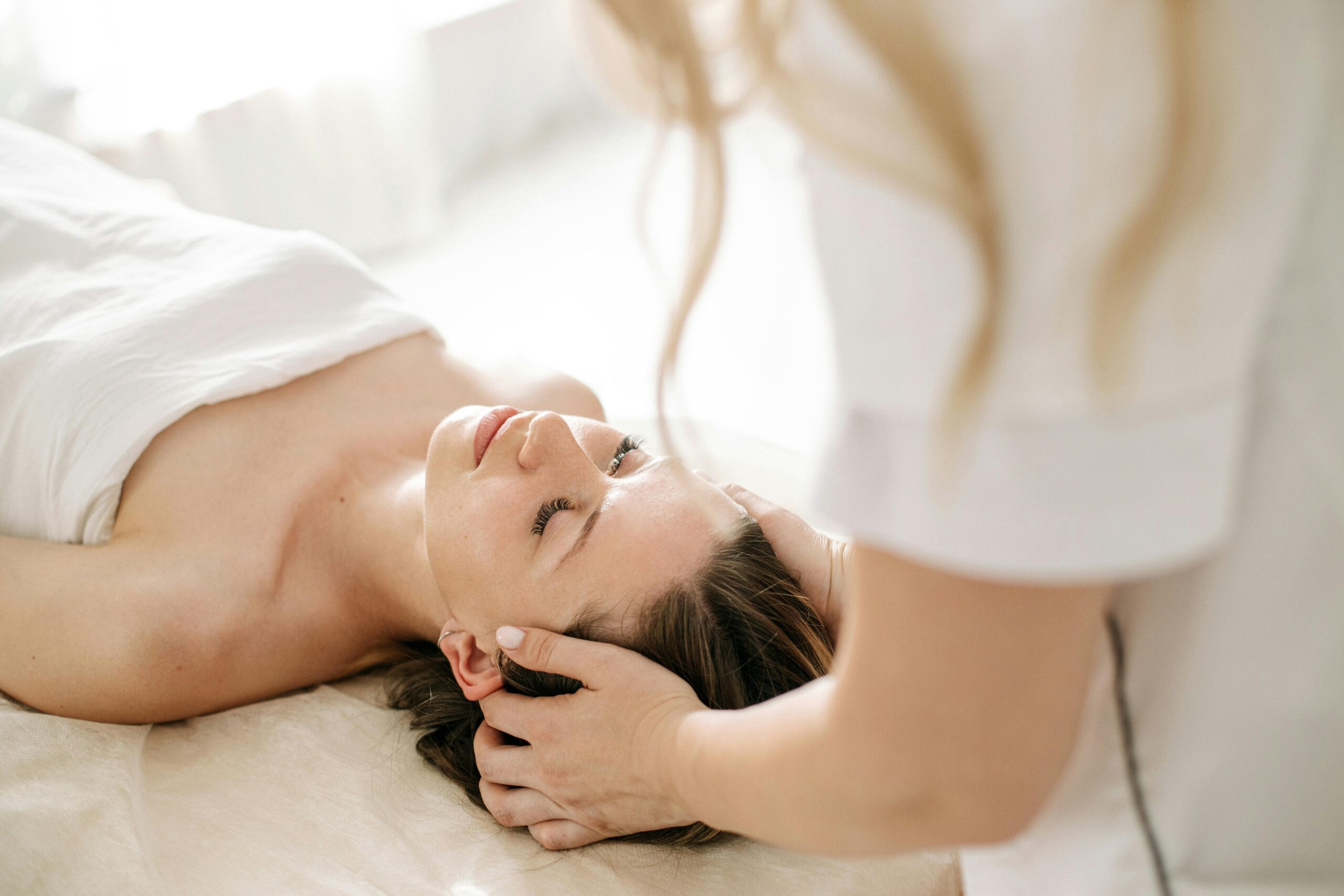 Services A woman receiving a calming head massage at a spa, promoting relaxation and wellness.